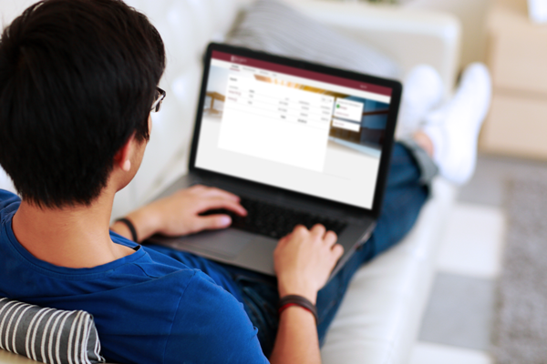 man doing online banking on his laptop on the couch