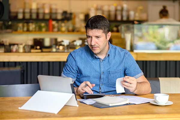 A man comparing receipts to his bank statement