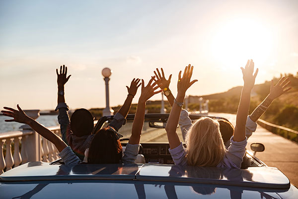 People driving a car with raised hands