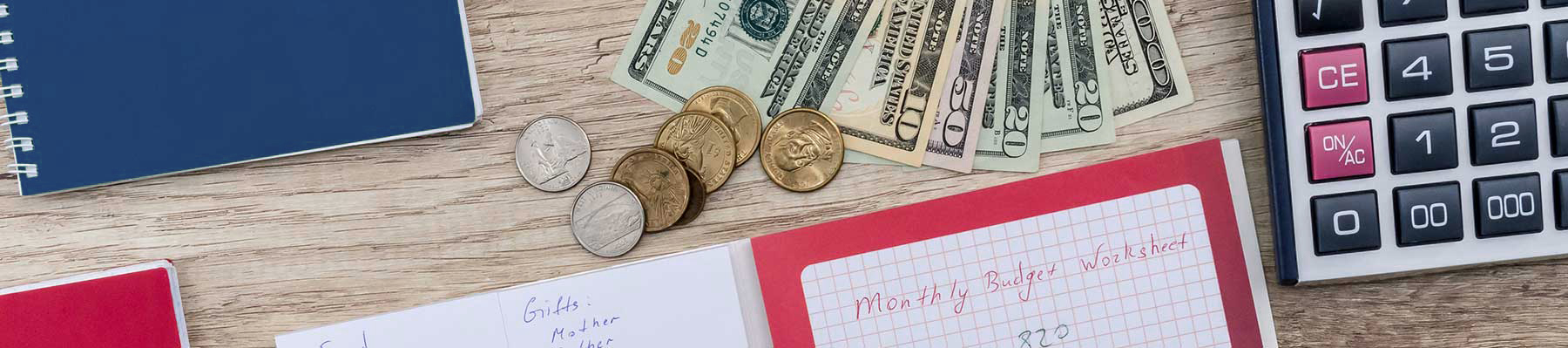 Monthly budget planning concept with calculators and currency on a wooden table